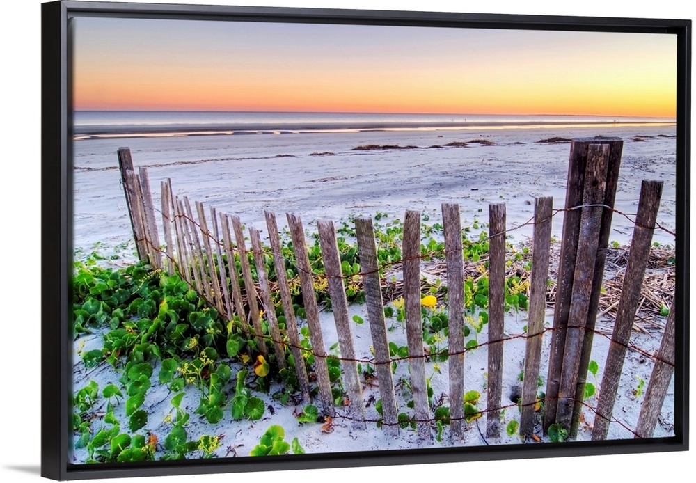 Wall art for the home or office this landscape photograph is of a battered barrier fence ends on the edge of the sandy sho...