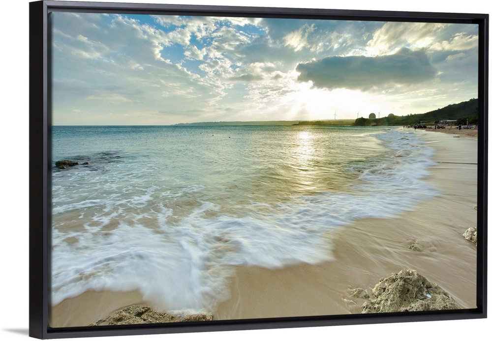 Nanwan, Kenting on  cloudy afternoon with foaming green sea water rushing in onto sandy beach with coral reefs and strong ...