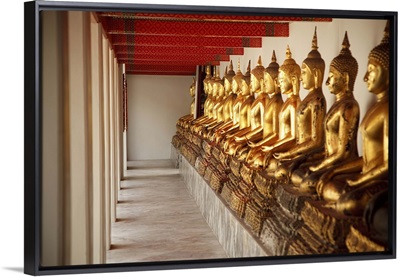 seated golden buddha statues in a row at wat pho, temple of the reclining buddha