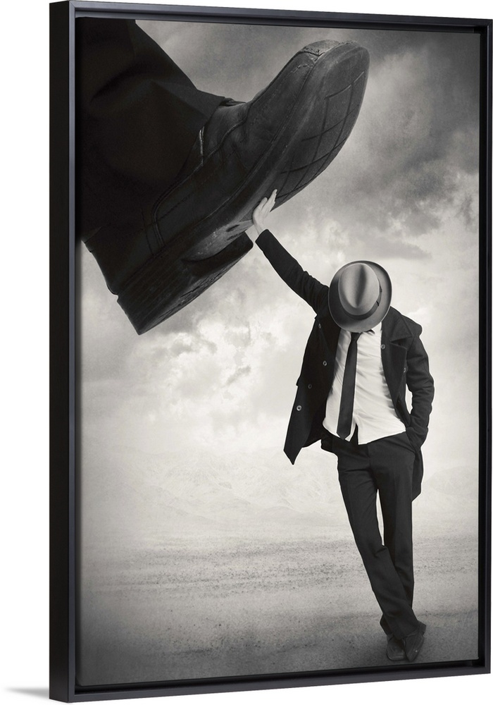 An abstract art photograph of a man wearing a hat and suit, leaning against a giant foot trying to step on him.