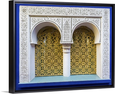 Ornate window against blue wall at Jardin Majorelle gardens