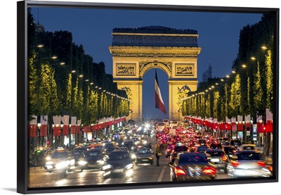 View down the Champs Elysees to the Arc de Triomphe, illuminated at dusk, Paris, France