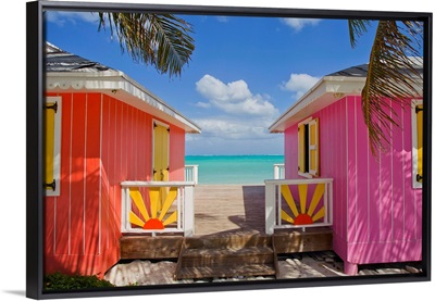 A typical tropical scene with colorful buildings, palms and water