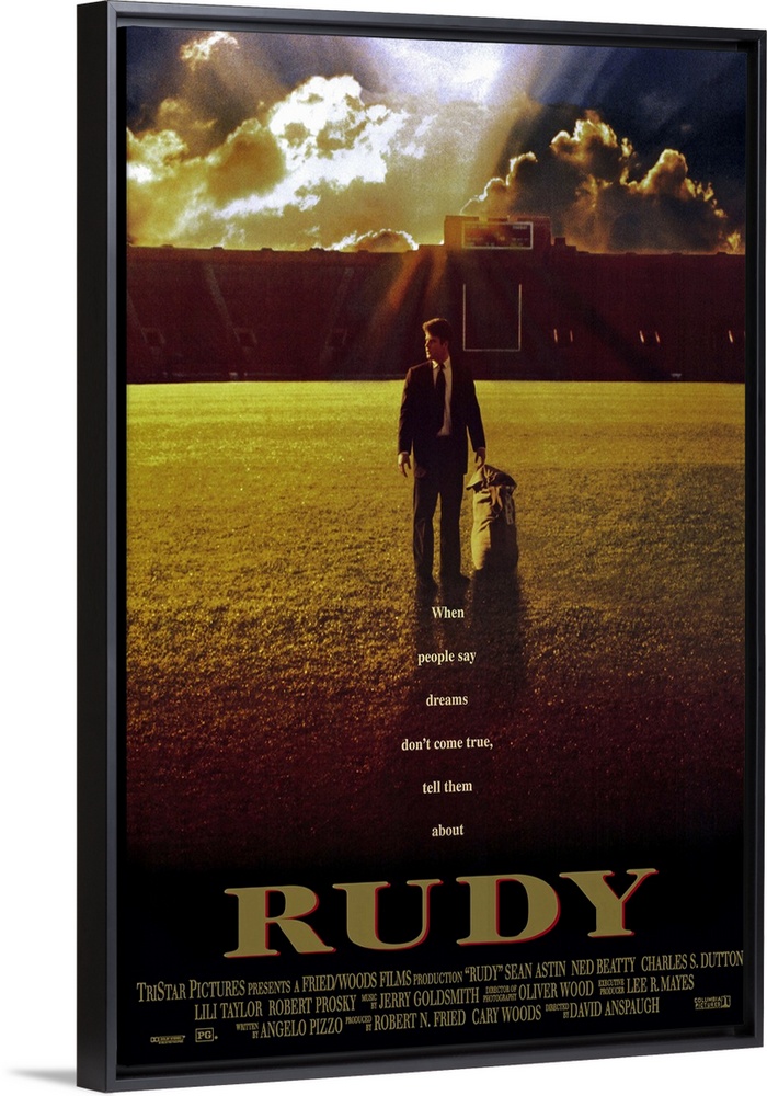 This large vertical piece is a movie poster for "Rudy". It pictures the star character walking across the football field i...