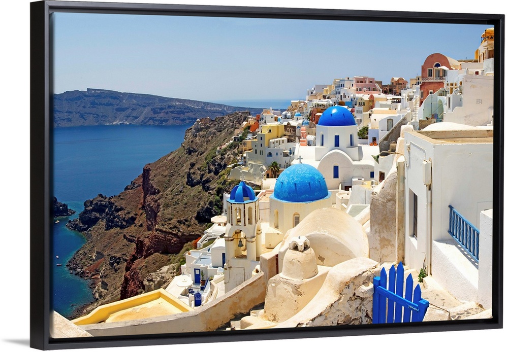 This hillside city with its famous colored roof tops overlooks a rocky Grecian sea in this panoramic photograph.