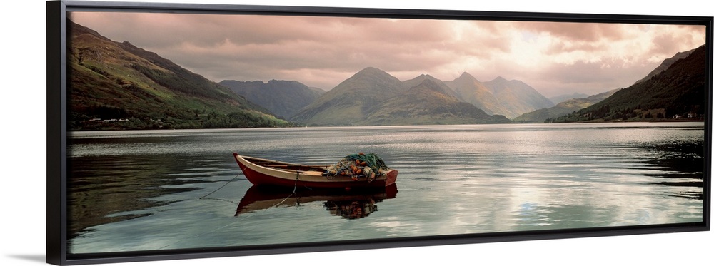 Panoramic photograph shows a small fishing vessel sitting anchored within a calm body of water north of the United Kingdom...