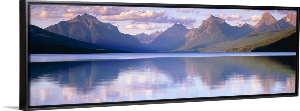 Oversized, horizontal photograph of mountains reflecting in the calm waters of Lake McDonald in Glacier National Park, Mon...