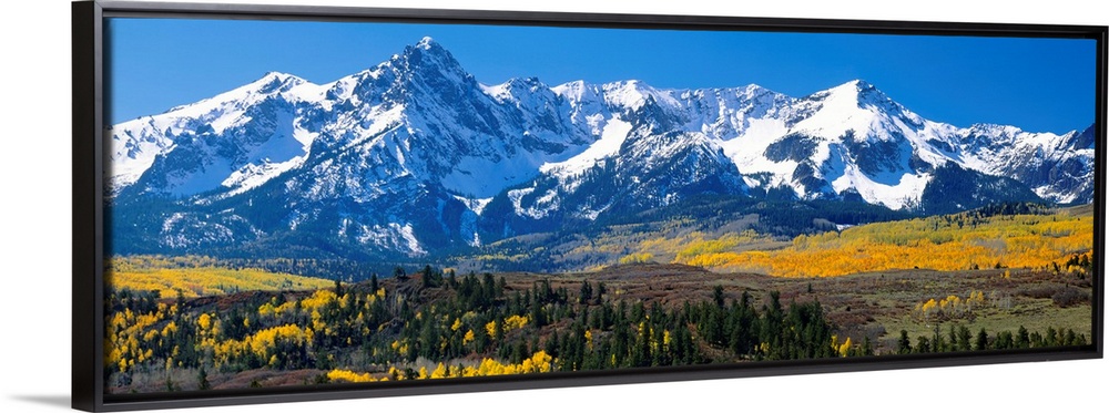 Panoramic image of a wilderness area at the base of a snowy mountain range.