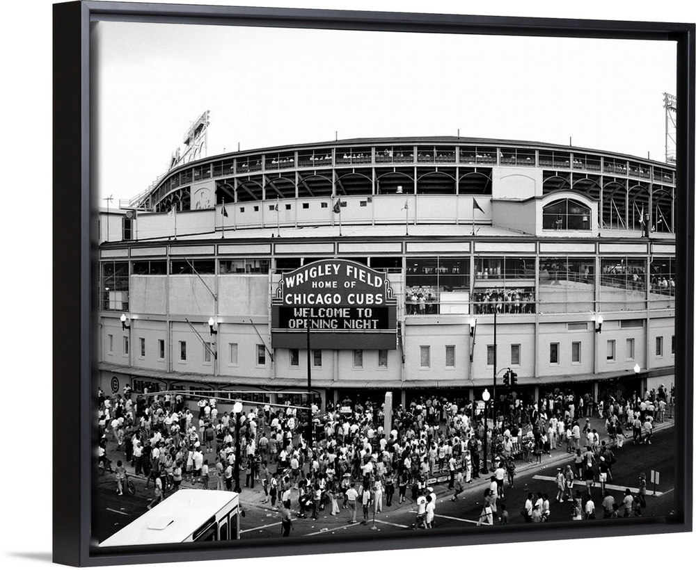 A black and white photograph taken outside of the Chicago Cubs stadium as fans are shown entering for the first game of th...