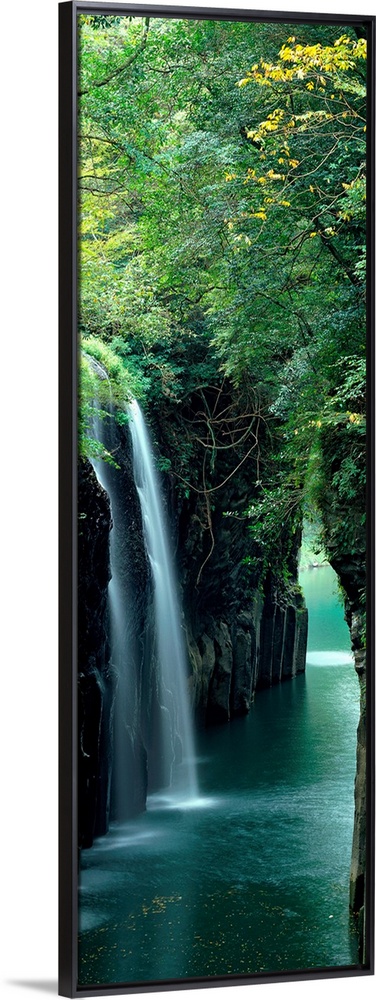 Vertical outdoor shot of a forest, river, and waterfall taken with time-lapsed photography.