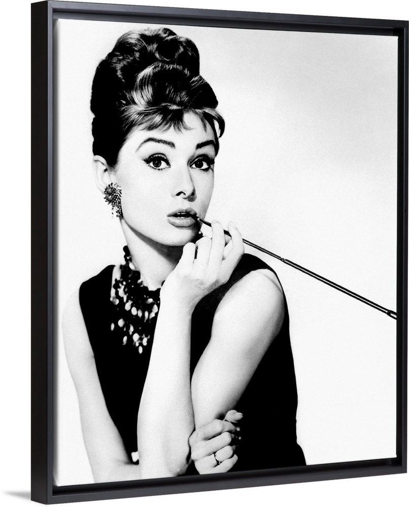 This wall art is a portrait photograph of the Hollywood Icon character Holly Golightly in her signature black dress, jewel...