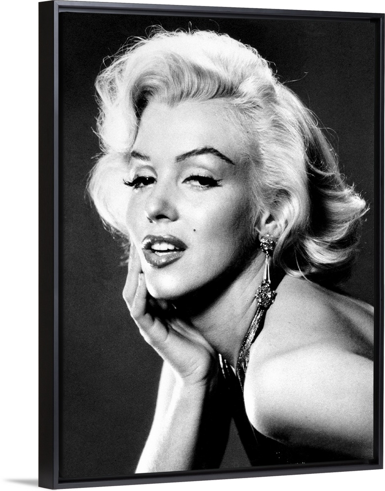 Large, portrait, black and white photograph of Marilyn Monroe, leaning forward with her palm on her face.