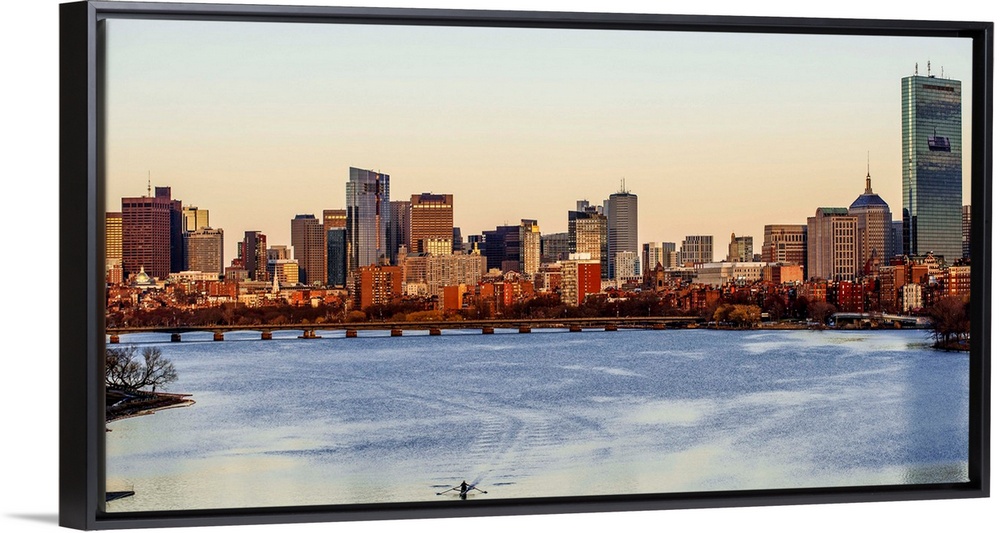 Panoramic view of the Boston City skyline at sunset, seen from across the water.