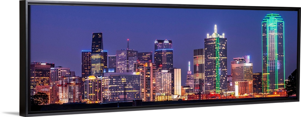 A horizontal image of the Texas city skyline at night.