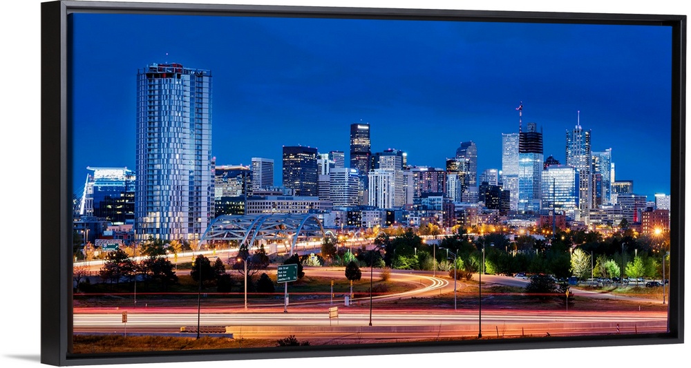 Photo of Denver's skyline at night with light trails.