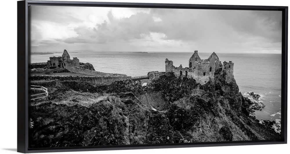 Landscape photograph of Dunluce Castle next to the ocean, taken from a higher point.