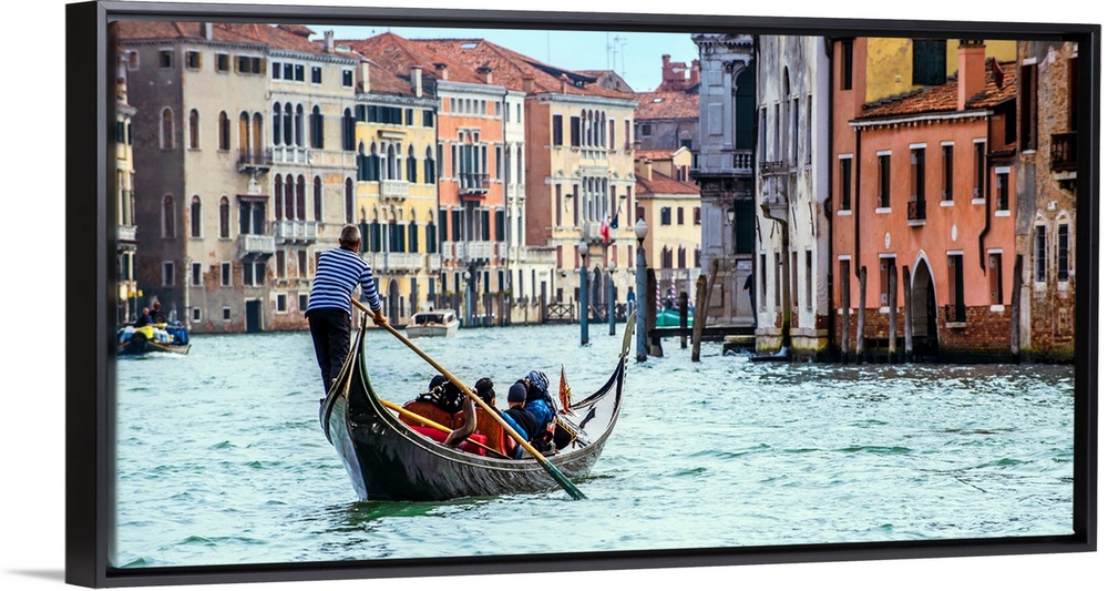 Photograph of the rear side of a gondola rowing through Grand Canal in Venice.