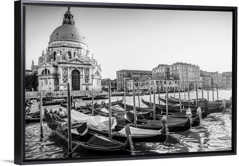 Photograph of gondolas lined up in a row in front of Santa Maria della Salute, Venice, Italy, Europe.