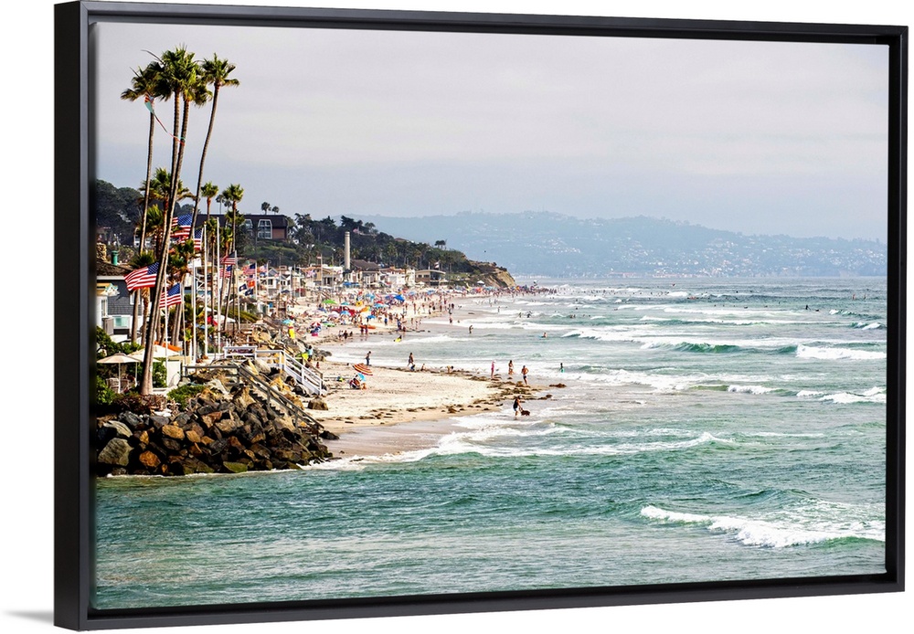 Landscape photograph of the La Jolla coast filled with beach goers and palm trees.