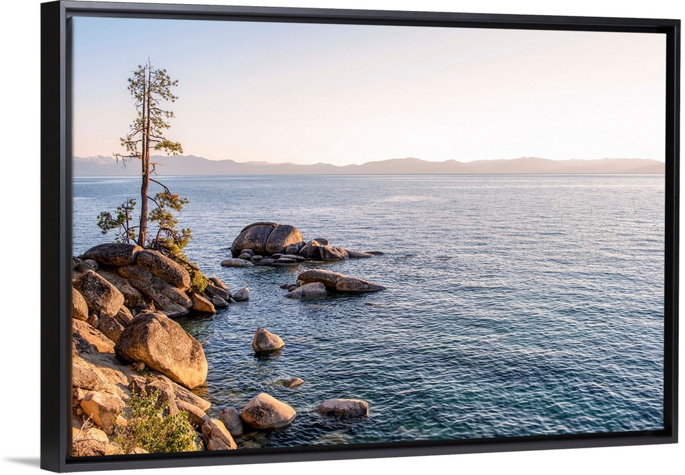 View of Lake Tahoe's rocky shore with mountain landscape in the background in California and Nevada.