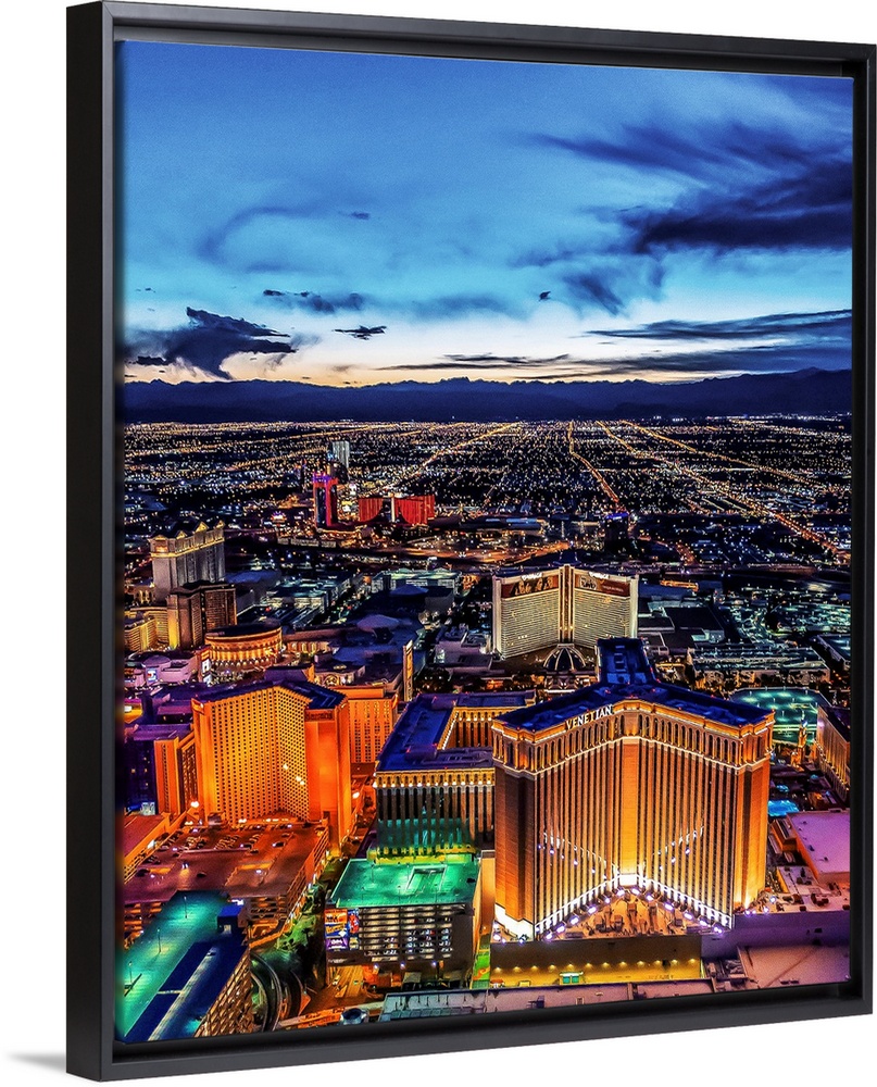 Aerial view of the Las Vegas Strip illuminated in the early evening with cloudy skies.