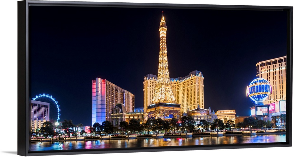 Panoramic photograph of the Las Vegas Strip lit up at night highlighting the Eiffel Tower Restaurant, hot air balloon, and...