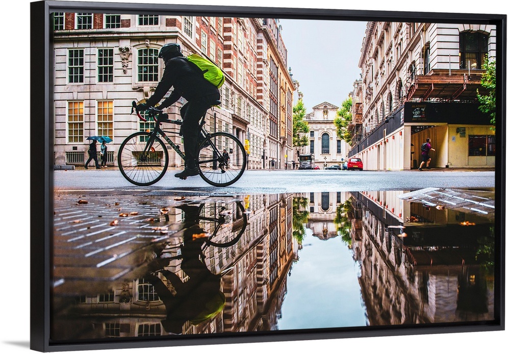 Photograph of a biker reflecting into a puddle in London, England.
