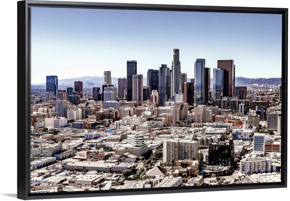 Skyscrapers and surrounding buildings of the Los Angeles skyline under a blue sky, California.