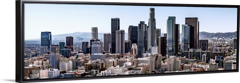 Panoramic photograph of skyscrapers and surrounding buildings of the Los Angeles skyline under a blue sky, California.