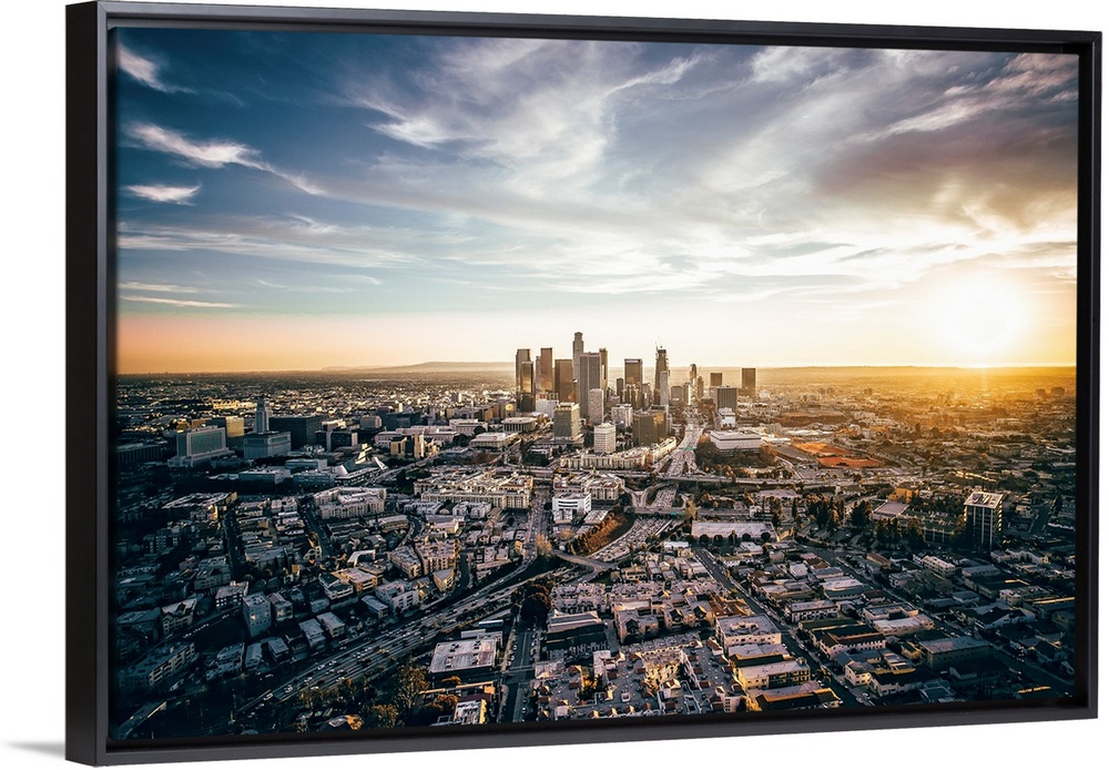 The setting sun visible behind the skyscrapers in the Los Angeles skyline, California.