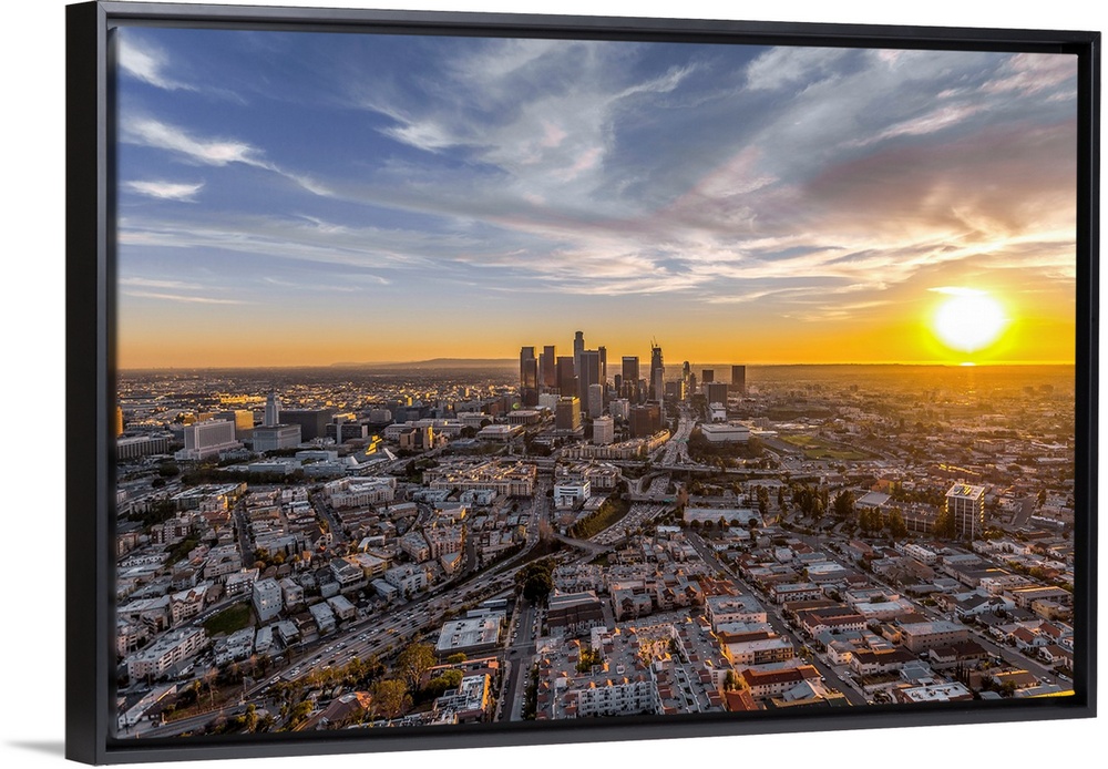 The setting sun visible behind the skyscrapers in the Los Angeles skyline, California.