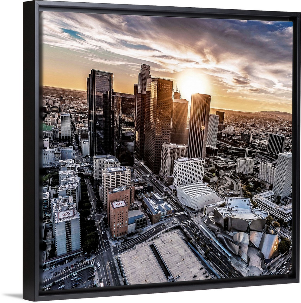 The setting sun visible behind the skyscrapers in the Los Angeles skyline, California.