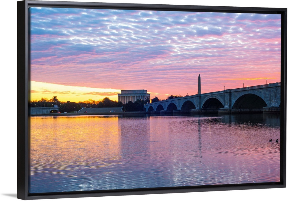 The Lincoln Memorial and Washington Monument seen from the Potomac River with pastel-colored clouds at dusk.