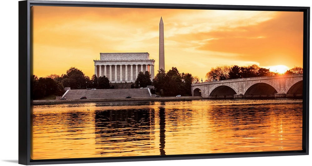 The Lincoln Memorial and Washington Monument seen from the Potomac River with orange clouds at dusk.