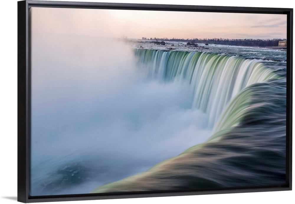 Water cascades down at Horseshoe Falls while dramatic mist ascents to meet the rising sun.