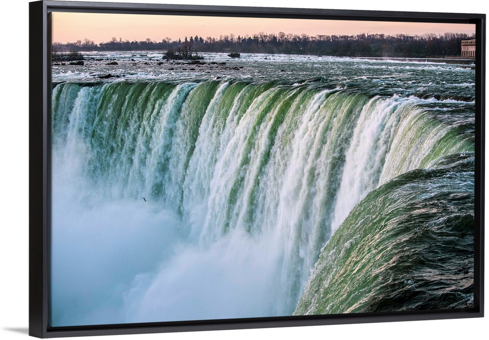 Water cascades down at Horseshoe Falls while dramatic mist ascents to meet the rising sun.