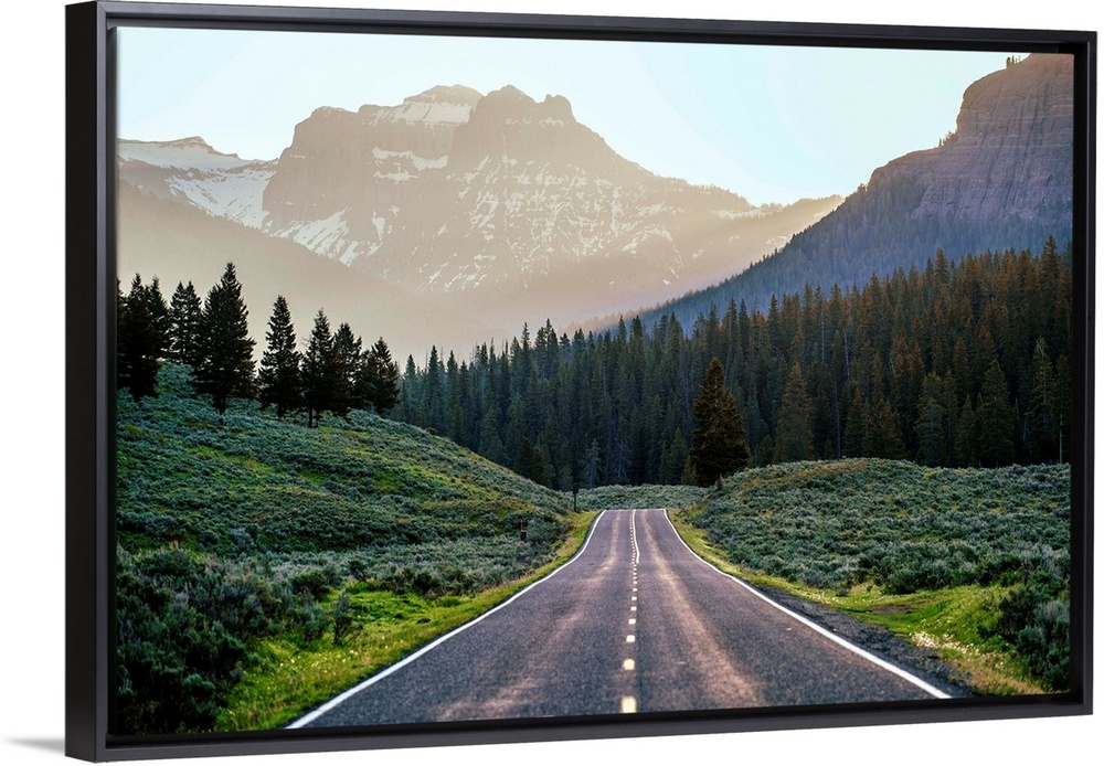 Horizontal image of a road heading to the mountains at Yellowstone National Park.