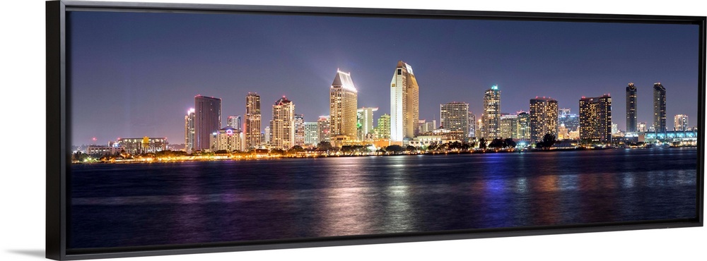 Panoramic photograph of the San Diego, California skyline lit up at night from across the water.