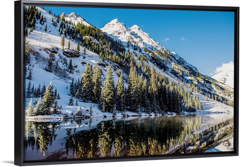 Summer snow on pine trees and the mountain side at the edge of Maroon Lake in the Maroon Bells, Aspen, Colorado.