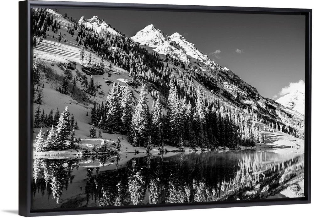 Summer snow on pine trees and the mountain side at the edge of Maroon Lake in the Maroon Bells, Aspen, Colorado.