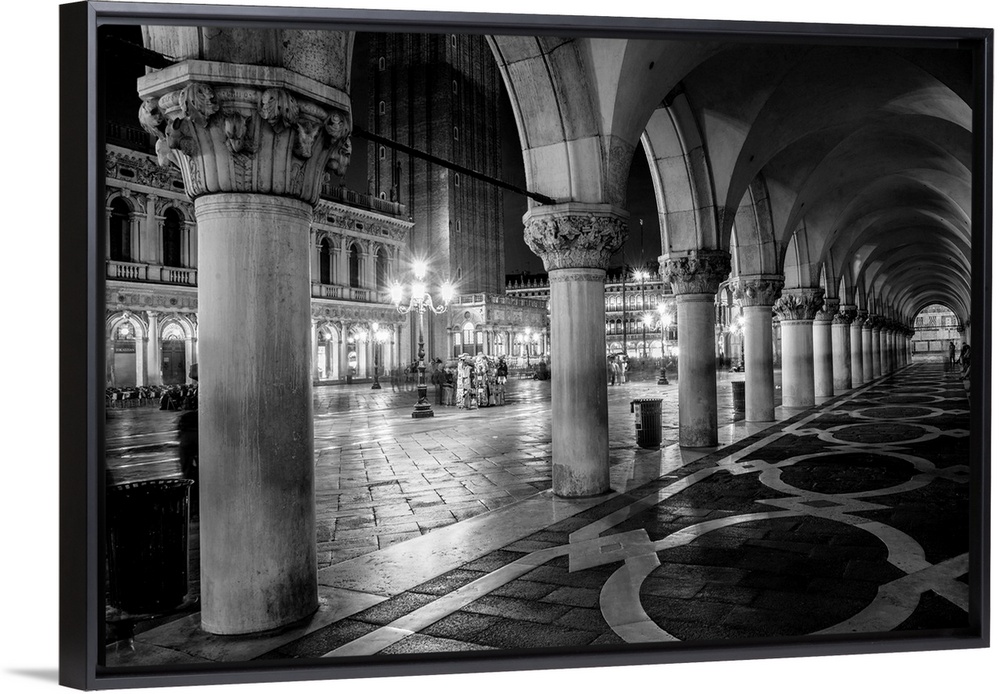 Photograph of the view from underneath arches at night in St. Mark's Square, Venice.