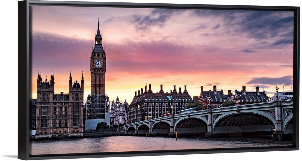 Panoramic photograph of Big Ben and the Westminster Bridge with a pink and purple sunset.