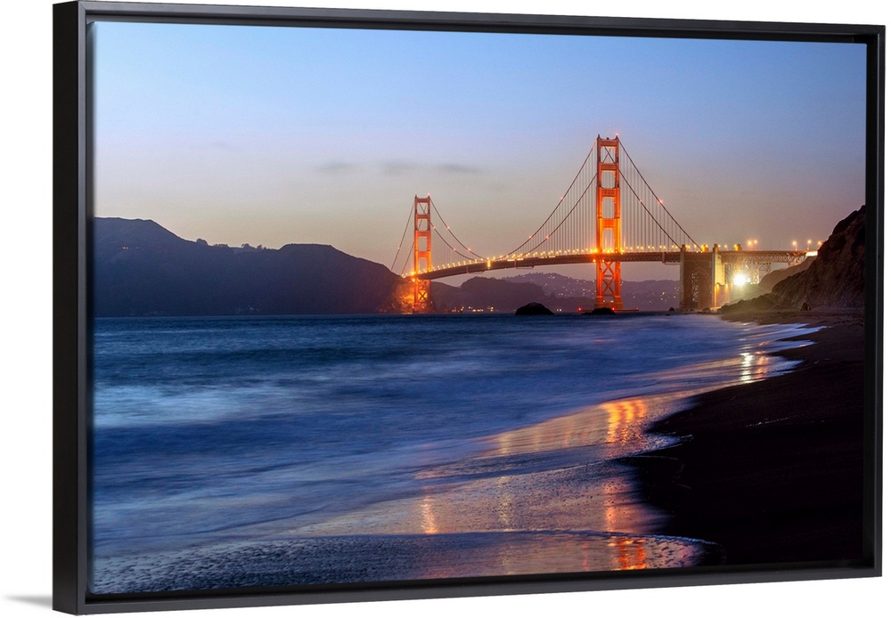 Twilight photograph of the Golden Gate Bridge taken from the shore.