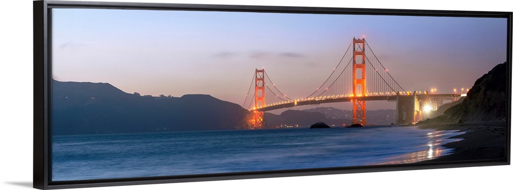 Panoramic photograph at twilight of the Golden Gate Bridge taken from the shore.