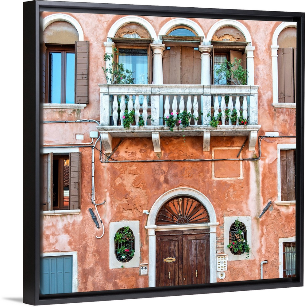 Square photograph of an Italian facade in Venice with a door, windows, and a balcony.