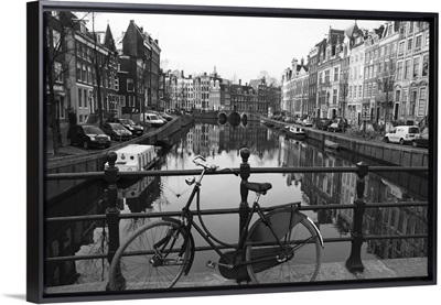 Black and white imge of an old bicycle by the Singel canal, Amsterdam, Netherlands