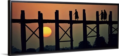 Monks walking across the Ubein Bridge in Burma at sunset