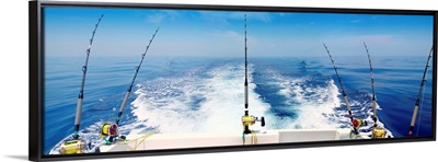 Fishing reels with cast lines off the back of a boat