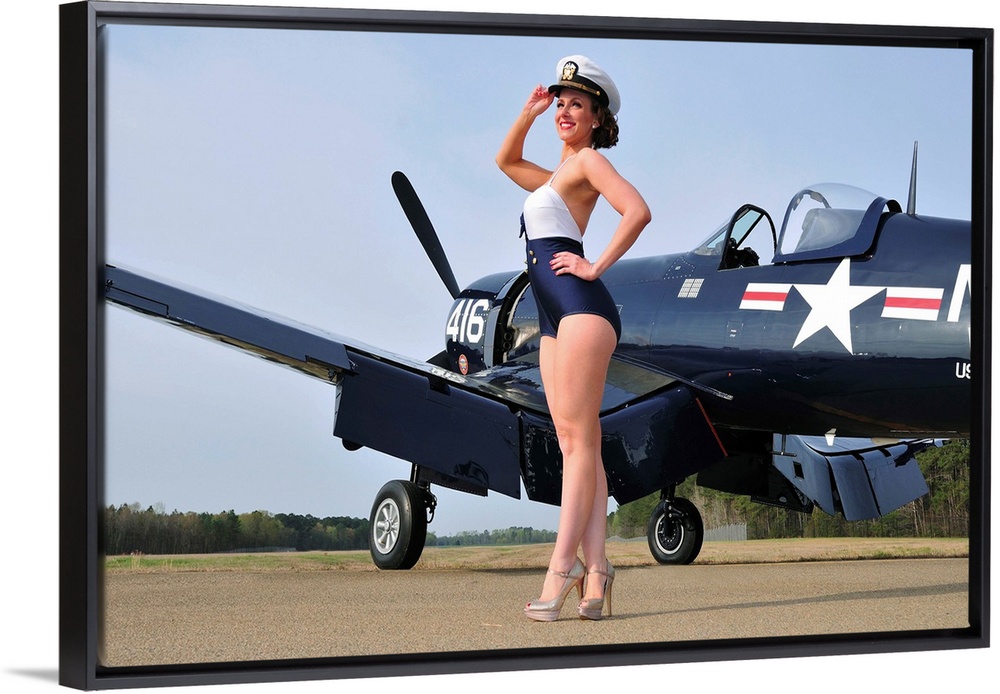 Beautiful 1940's style Navy pin-up girl posing with a vintage Corsair aircraft.
