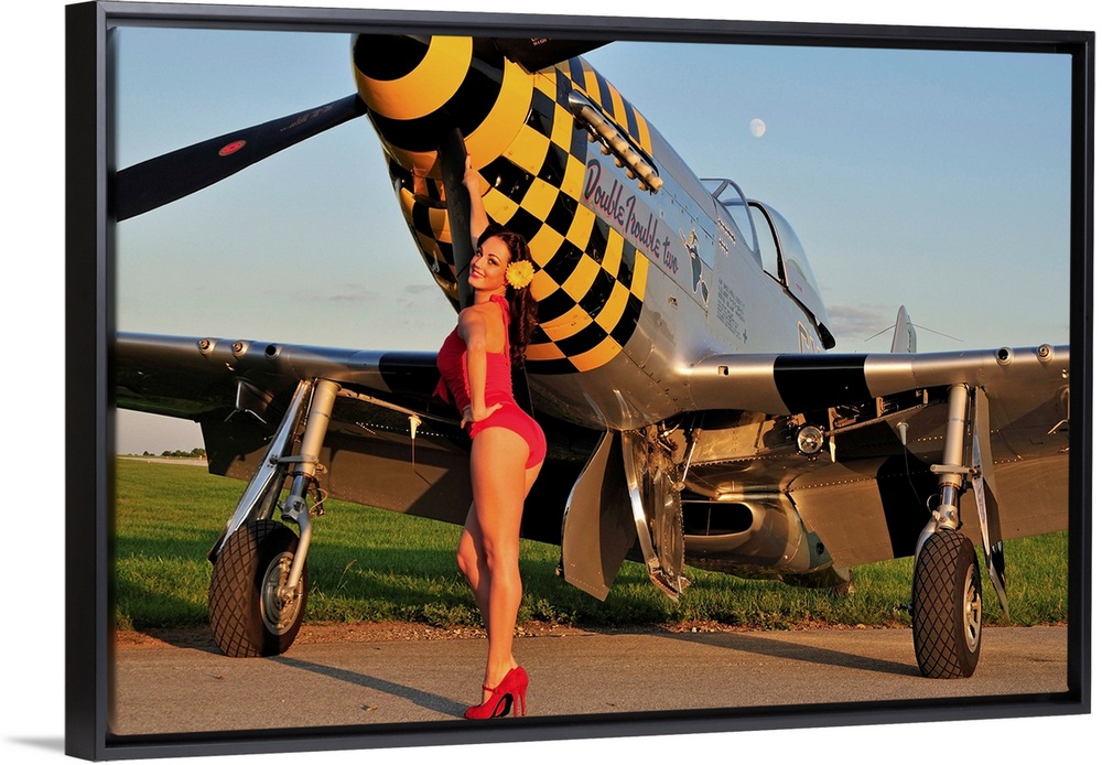 Sexy 1940's style pin-up girl posing with a P-51 Mustang fighter plane.